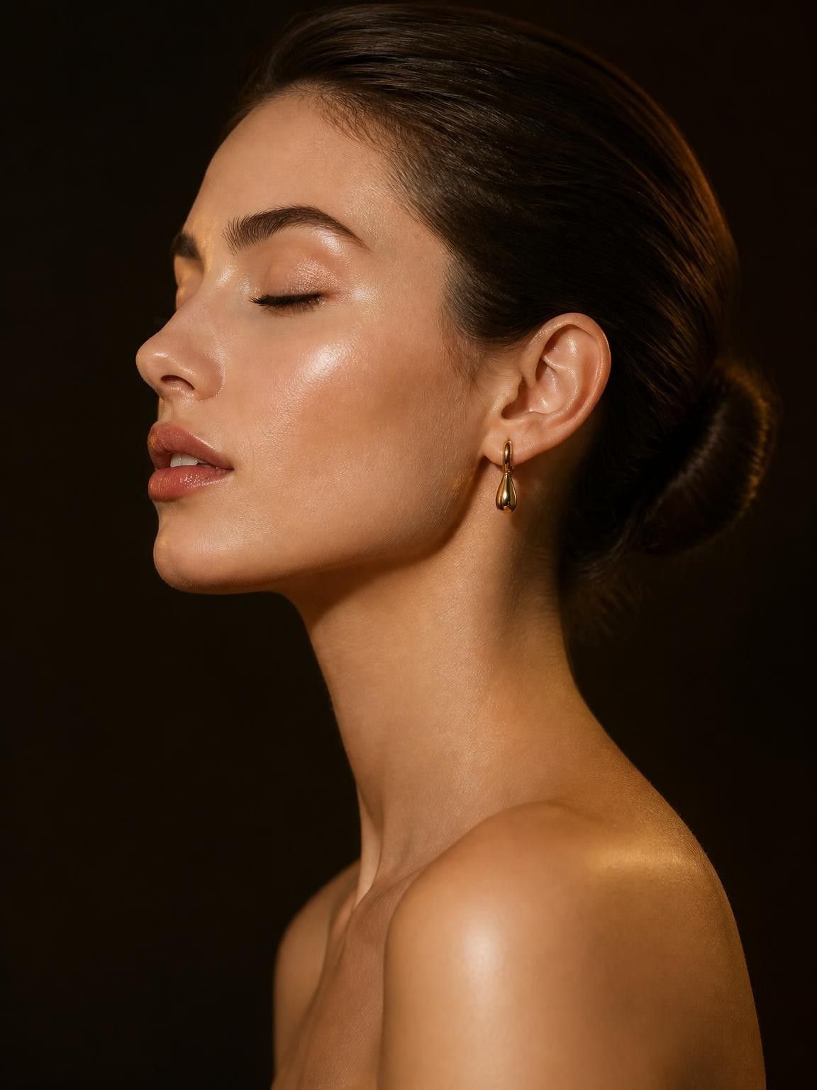 Perfil de mulher com pele iluminada em fundo escuro